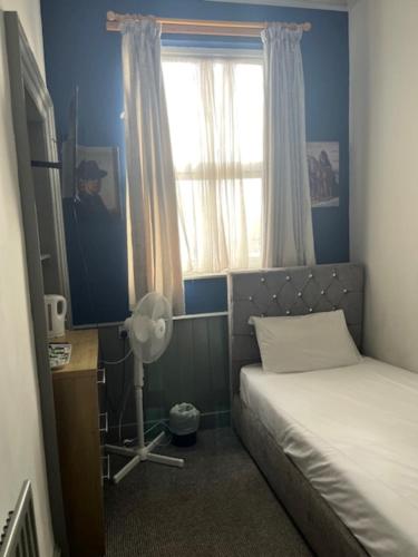 a small bedroom with a bed and a window at OYO Ivy Hotel in Skegness