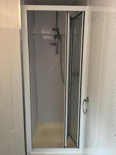 a glass shower door with a mirror in a bathroom at OYO Ivy Hotel in Skegness