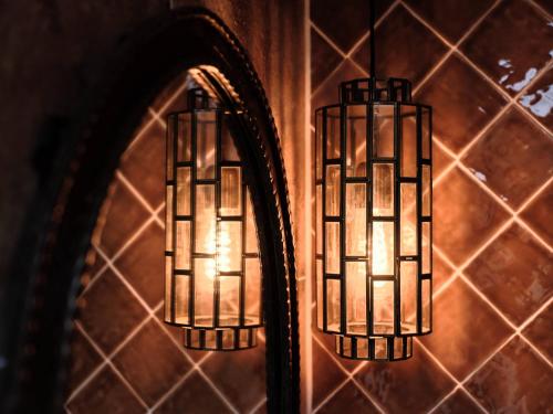 two lights hanging on a wall with a mirror at Hajé Nieuwegein in Nieuwegein