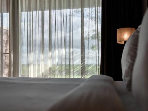 a bedroom with a bed and a window with blinds at Hajé Nieuwegein in Nieuwegein