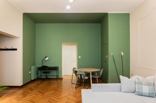 a living room with green walls and a white couch at The Gate by Zoia Living in Athens