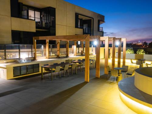 a rooftop patio with tables and chairs on a building at The Sebel Melbourne Malvern in Melbourne