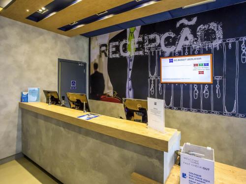 a lobby with a reception desk with a presentation at Íbis Budget Uberlândia in Uberlândia