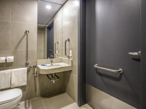 a bathroom with a toilet and a sink at Íbis Budget Uberlândia in Uberlândia
