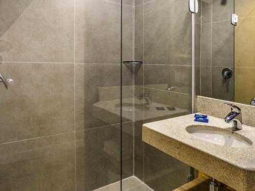 a bathroom with a shower and a sink at Íbis Budget Uberlândia in Uberlândia