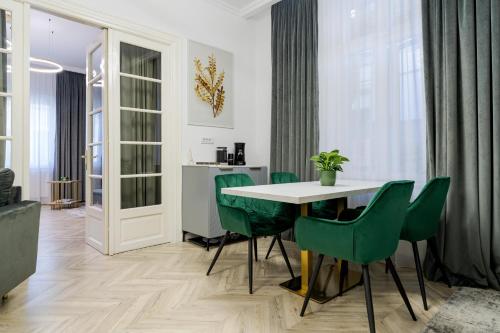 a dining room with a table and green chairs at Villa for rent with Garden - High Ceilings Bucharest Free Park in Bucharest