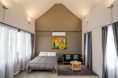 a bedroom with a bed and a chair at Crownex Studio Deluxe in Ban Nong Chaeng