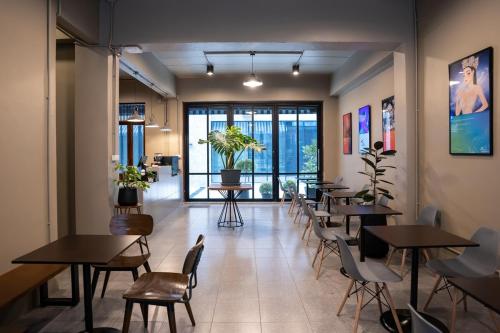 a restaurant with tables and chairs in a room at Crownex Studio Deluxe in Ban Nong Chaeng