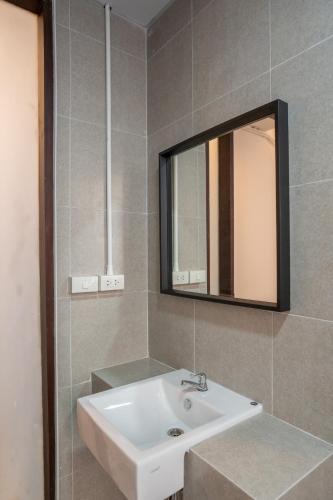 a bathroom with a sink and a mirror at Crownex Studio Deluxe in Ban Nong Chaeng