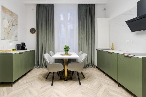 a kitchen with green cabinets and a table and chairs at Villa for rent with Garden - High Ceilings Bucharest Free Park in Bucharest