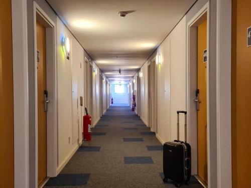 a hallway with a long corridor with luggage in a building at ibis budget Petropolis in Petrópolis