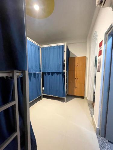 a room with blue curtains in a room at Hostel De Offlanders Rishikesh - Stay Connect & Explore in Tapovan