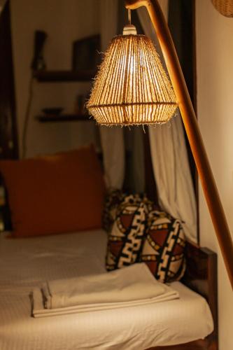 a lamp sitting on top of a bed at Babu Villas in Jambiani