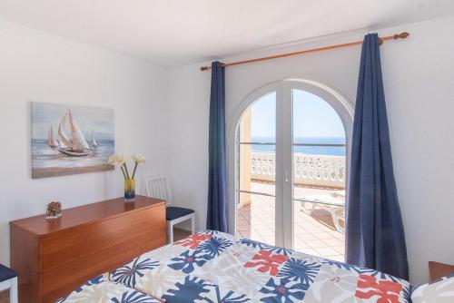 a bedroom with a bed and a window with a view of the ocean at Ocean Pearl Loma Verde in Patalavaca