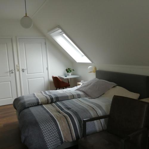 a bedroom with a large bed with a light on it at Veenemaat in Winterswijk