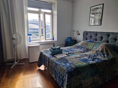 a bedroom with a bed and a window and a fan at Charming room by Rock Church in Helsinki