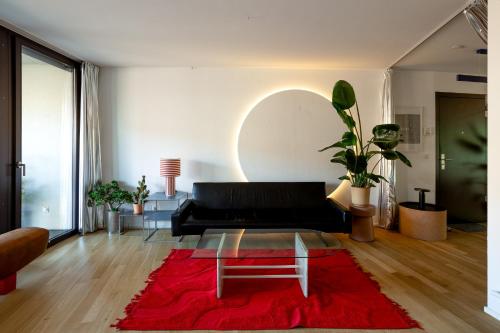 a living room with a black couch and a red rug at Urban Design Loft - Basel - Free Parking in Basel