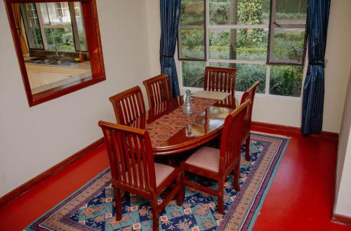 un comedor con una mesa y sillas de madera en Protea House, en Marombosa