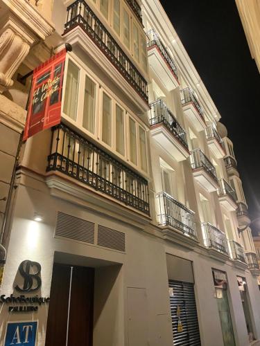 a building with a balcony on the side of it at Apartamentos Soho Boutique Palillero in Cádiz