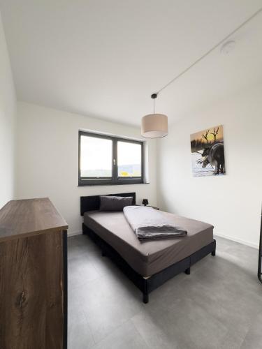 a bedroom with a bed and a picture on the wall at Apart das Ehrets mit 3 Schlafzimmer in Bretzfeld
