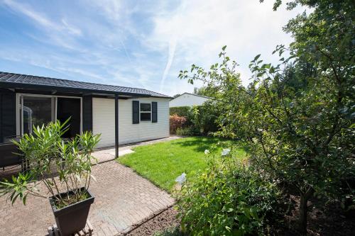 a backyard of a house with a garden at Woudcottage met airco! in Oisterwijk