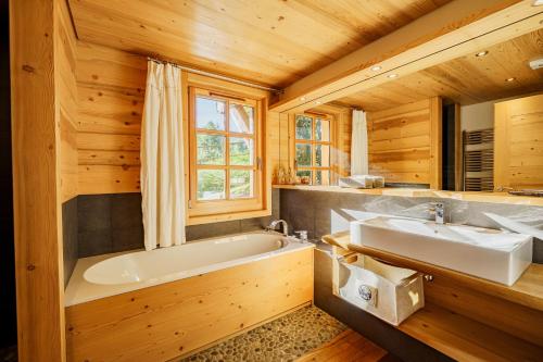 a bathroom with a tub and a sink at Chalet des Sommets in Combloux