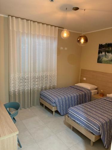a bedroom with two beds and a window with curtains at Borgo Carpino in Ripi