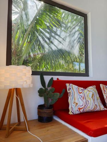a red couch in a room with a potted plant at Filao villa in Riambel