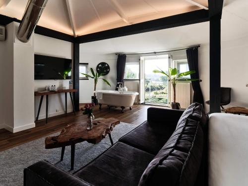a living room with a couch and a bath tub at Hajé Hotel Restaurant de Lepelaar in Lelystad