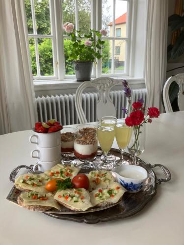 a tray with food and drinks on a table at B&B Österlens RosenTrädgård in Glemmingebro