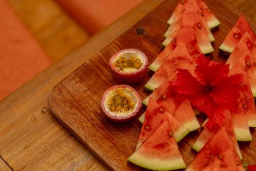a wooden cutting board with sliced fruit on it at Babu Villas in Jambiani