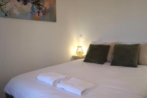 a bedroom with a white bed with two towels on it at Le Jardin de Sauge in Le Teich