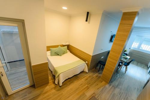 a small bedroom with a bed and a desk at Apartamento Reyes Católicos Conil in Conil de la Frontera