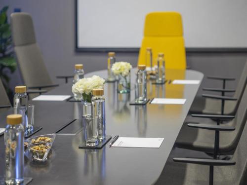 a conference room with a long table with yellow chairs at Pullman Santiago El Bosque in Santiago