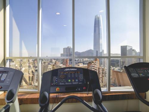 a gym with a view of a city from a window at Pullman Santiago El Bosque in Santiago