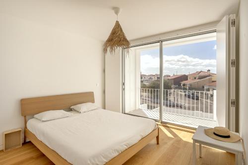 una camera da letto con un letto e una grande finestra di Ericeira Modern & Bright with Pool by Homing a Barril