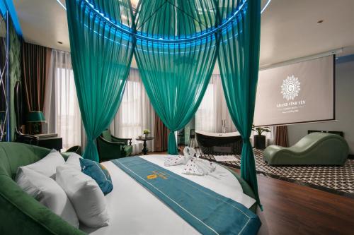 a bedroom with a large bed with blue curtains at Grand Hotel Vinh Yen in Vĩnh Phúc