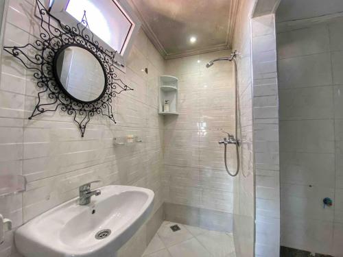 Un baño blanco con lavabo y espejo. en Ocean Vibes Sea View and Fast Wi-Fi, en Tánger