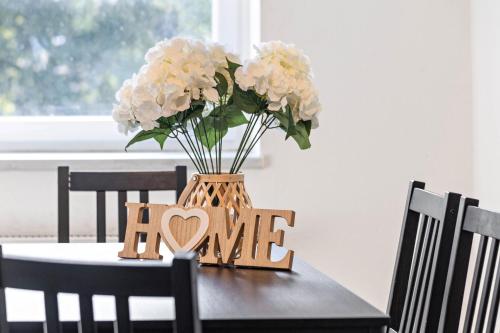 a table with a vase of flowers and a sign that says love at Key2Komfort in Duisburg