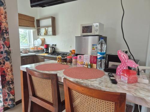 a kitchen with a counter with two chairs and a counter top at Coco Lux Mon Amour in Grand Baie