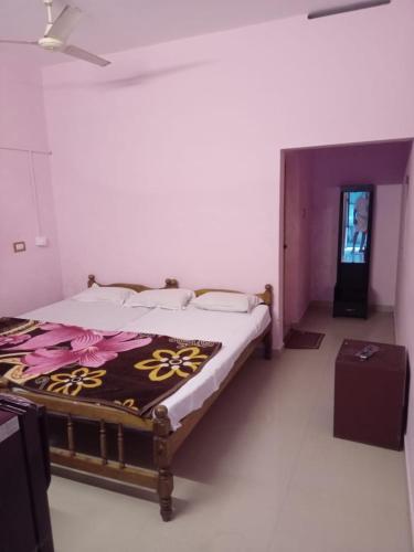a bedroom with a bed with a blanket on it at Golden Stay in Varkala