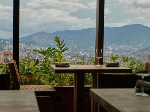 a table and chairs with a view of a city at Novotel Medellin El Tesoro in Medellín