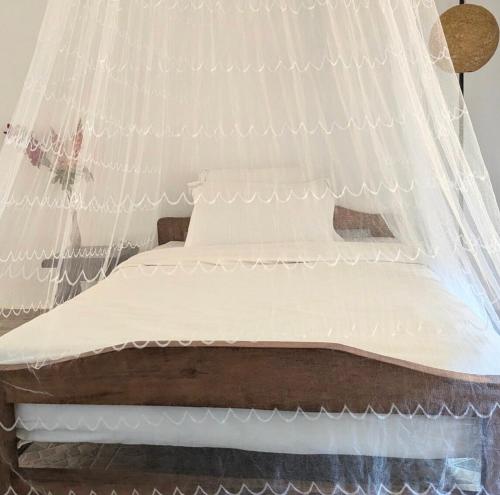 a bed with mosquito netting on top of it at Private Rooms Ensuite Bathroom Garden Access in Kigali