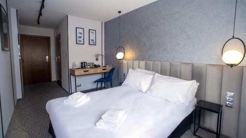 a bedroom with a white bed with two towels on it at B&B HOTEL Piotrków Trybunalski in Piotrków Trybunalski