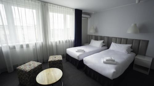 a hotel room with two beds and a table at B&B HOTEL Piotrków Trybunalski in Piotrków Trybunalski