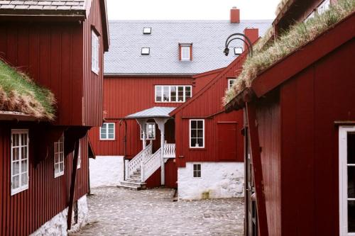 a row of red buildings with stairs between them at Modern Apartment with Balcony & Stunning Views in Argir