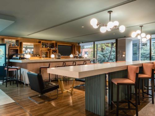 a kitchen with a bar with a table and chairs at Novotel Bogota Parque 93 in Bogotá