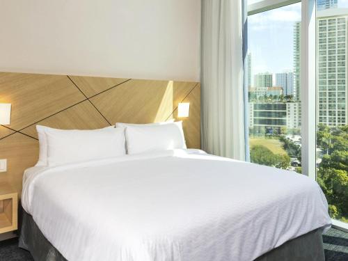a bedroom with a large bed and a large window at Novotel Miami Brickell in Miami