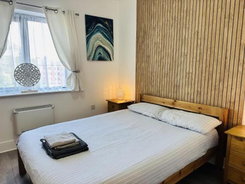 a bedroom with a bed with a bag on it at Grand Central Apartments in Derby