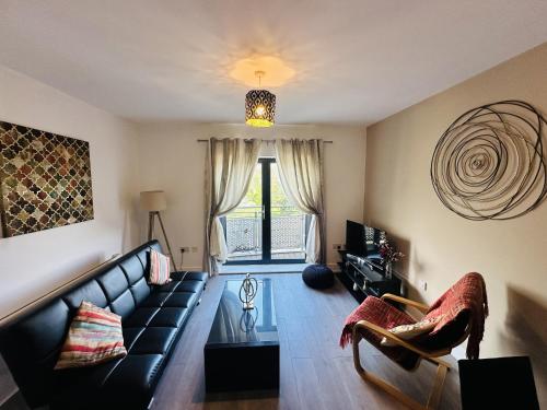 a living room with a black couch and a window at Grand Central Apartments, Centro in Derby